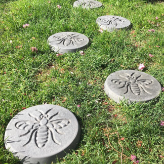 Pack of 6 bee design stepping stones in a charcoal colour.